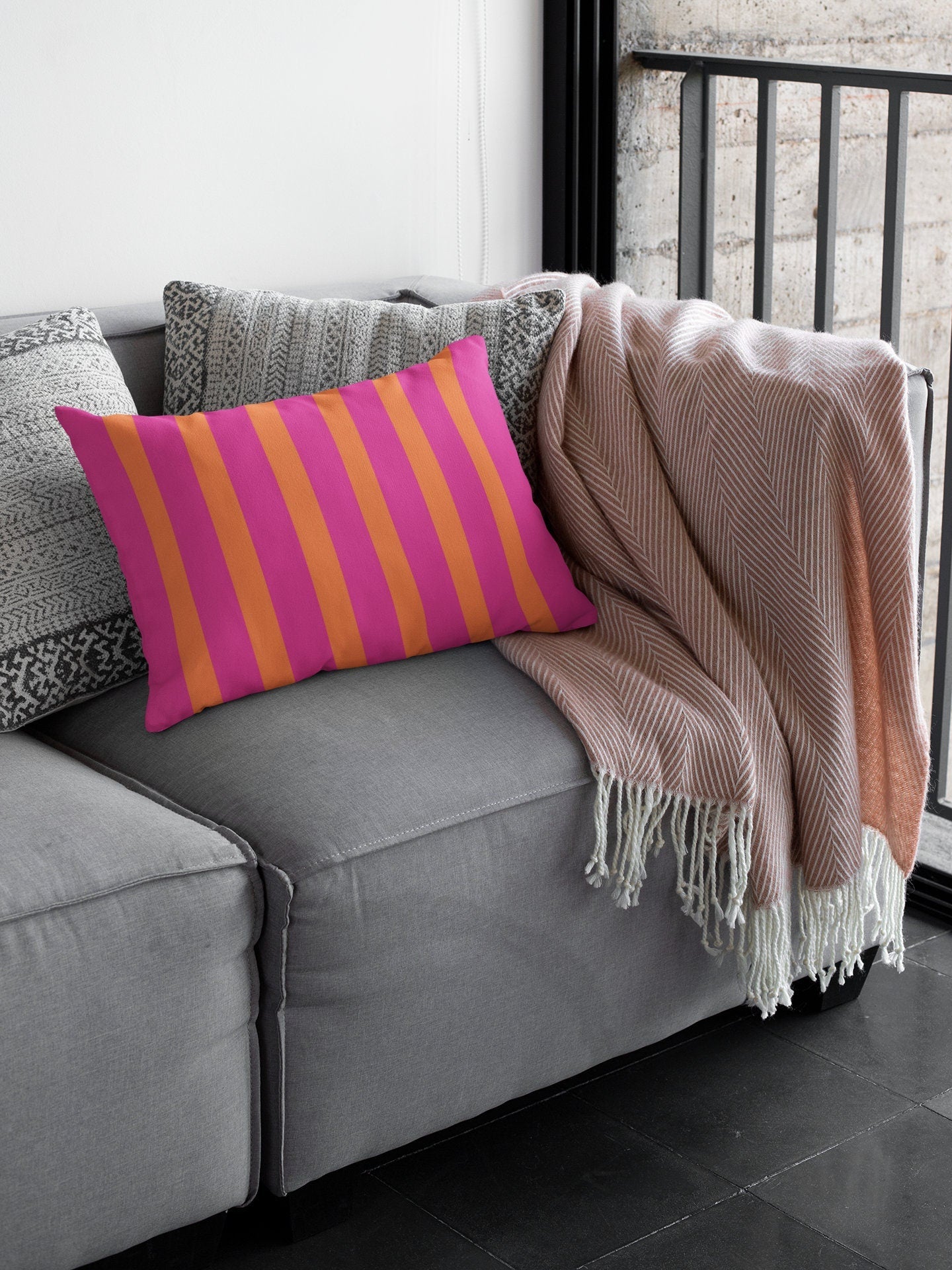 orange and pink striped pillow on patio couch